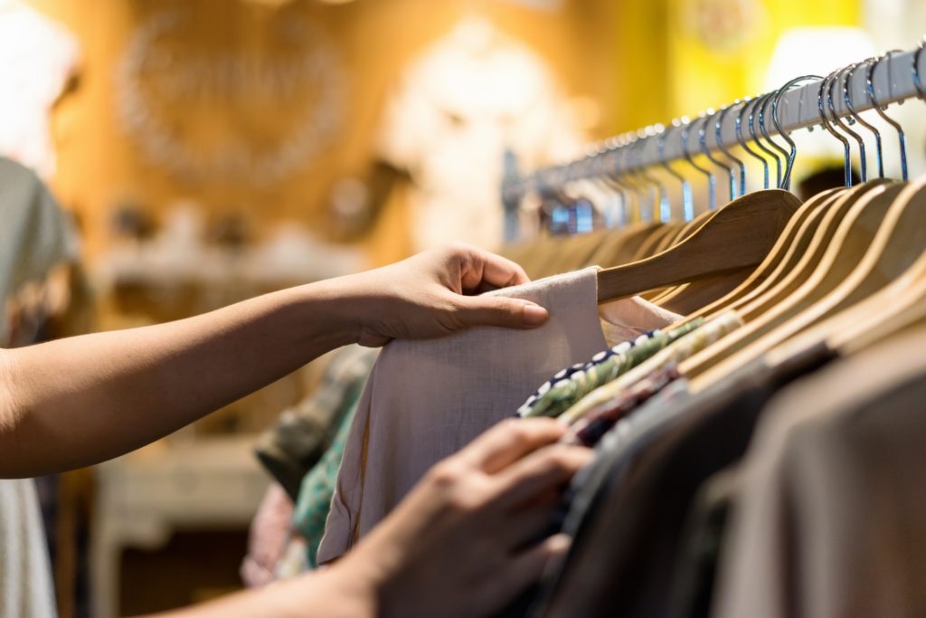 A woman holding a garment on a rack