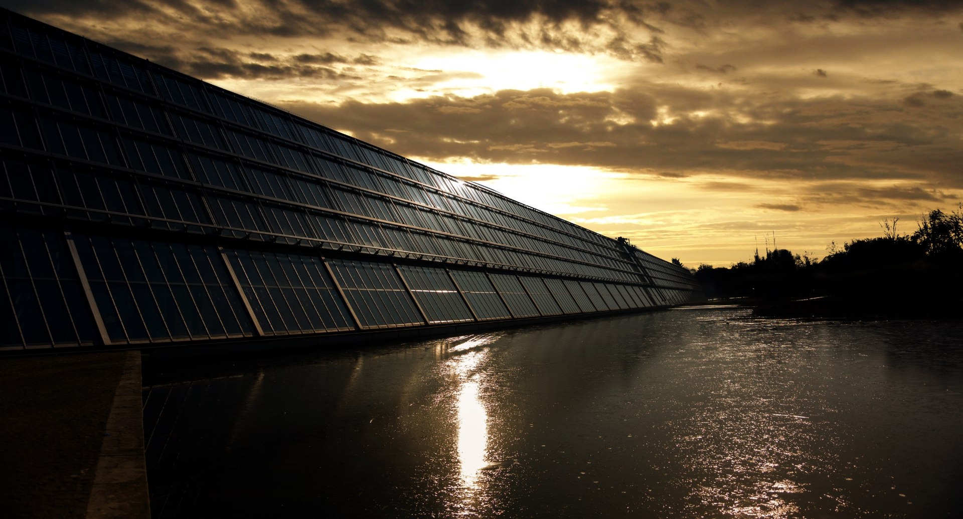 Photovoltaic solar panels above a body of water