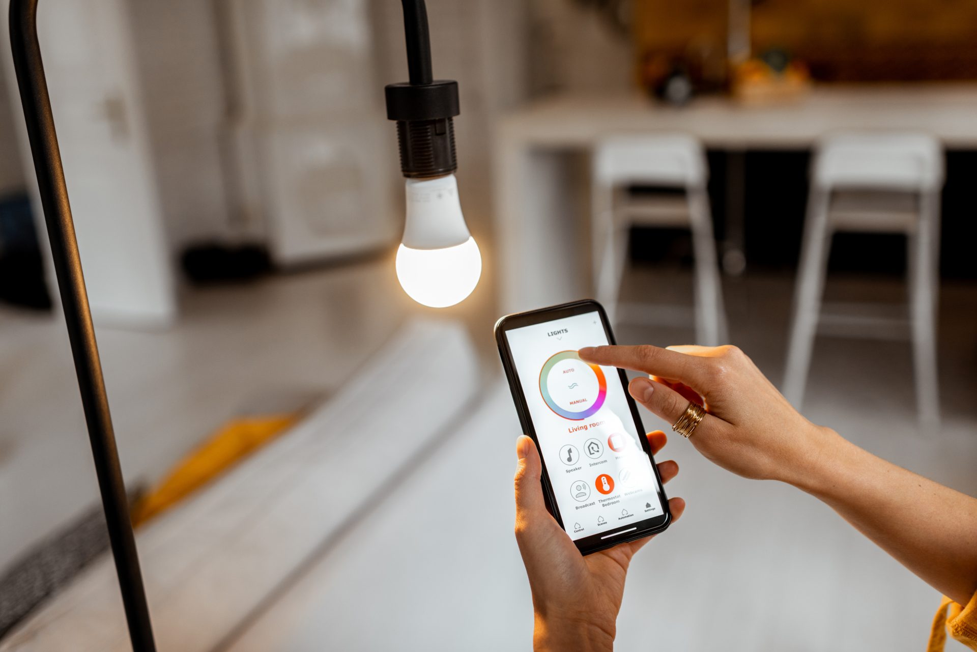 Someone controlling a smart bulb with their phone