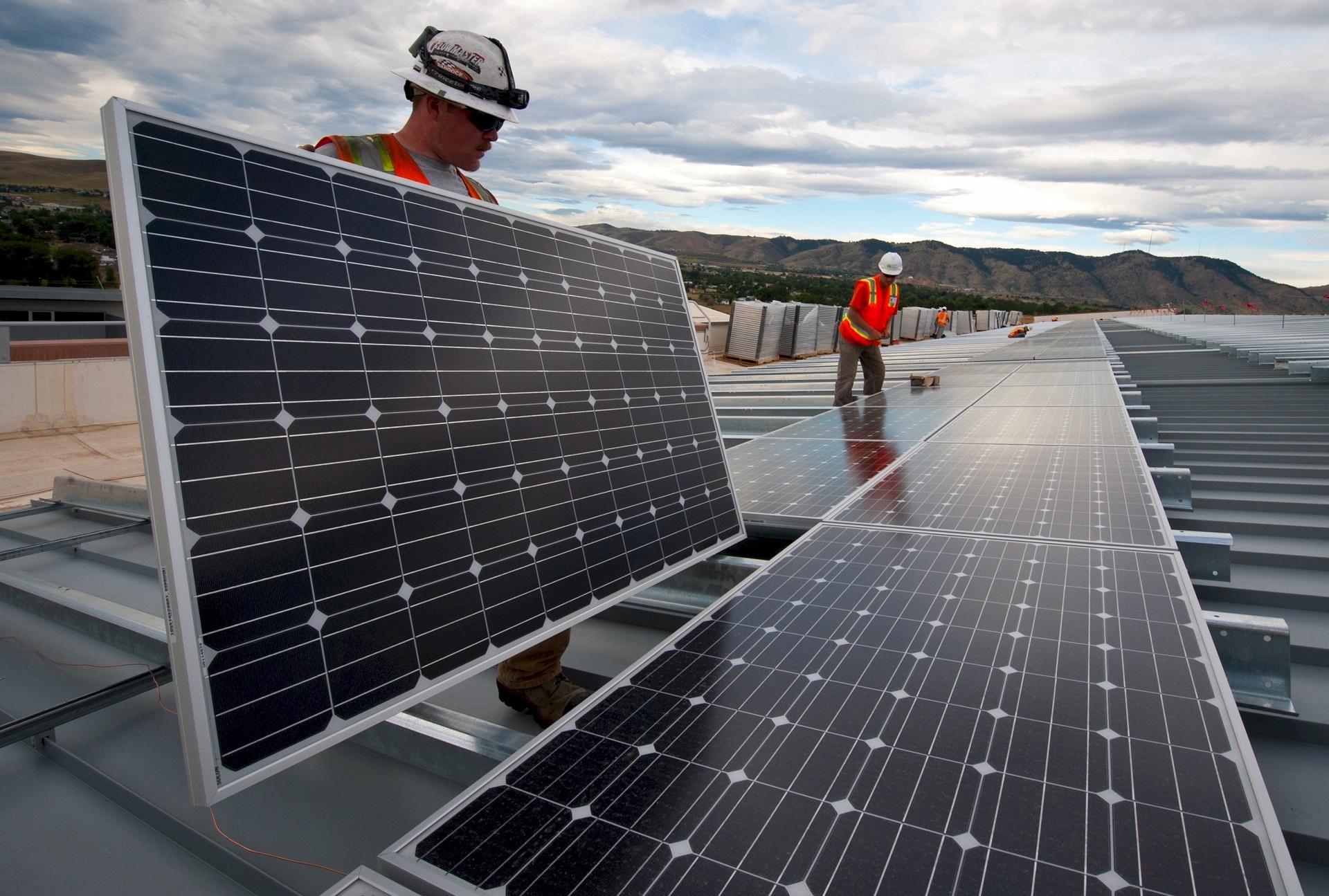 Photovoltaic solar panels being installed on a utility-scale solar farm