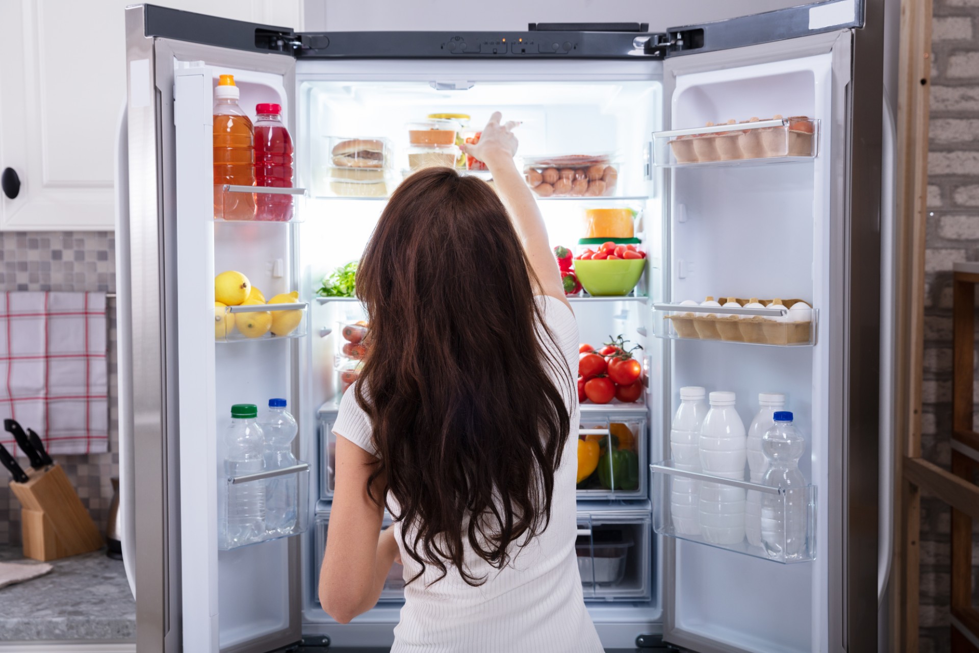 Woman reaching into the refrigerator