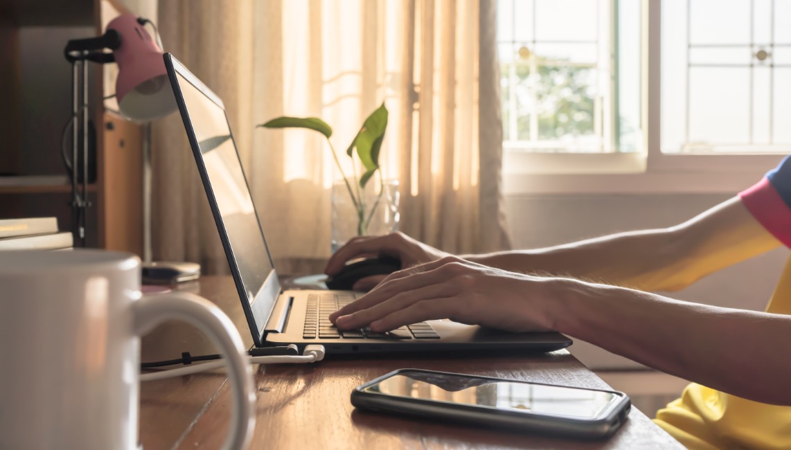 Someone working from home typing on their computer